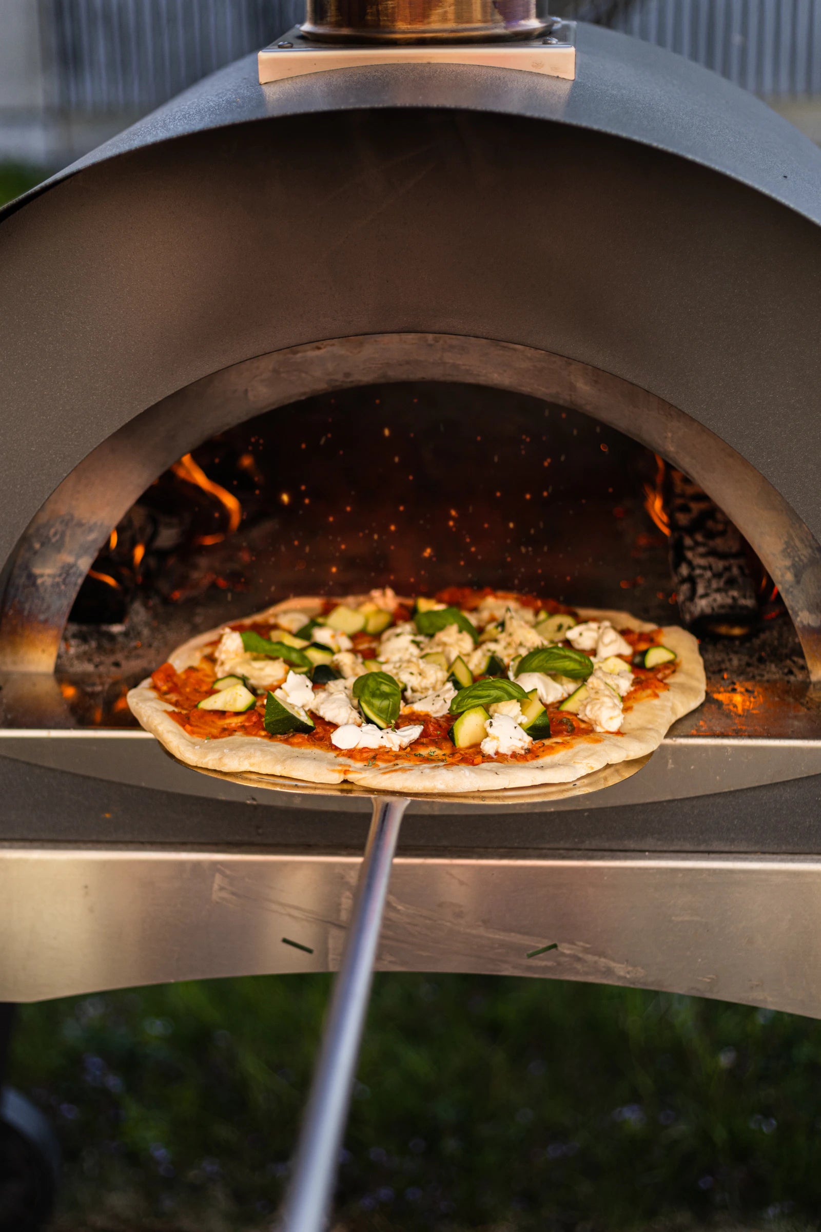 A glowing wood-fired pizza oven